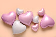 © Pixel-Shot - Heart shaped air balloons on beige background. Valentine's Day celebration