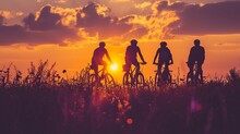 Silhouette Of Cyclists With Bicycles At Sunset.