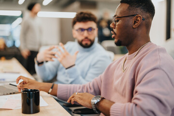 Multicultural business team discussing documents management in a pleasant atmosphere with creative people collaborating on product development and discussing marketing strategy for revenue growth.