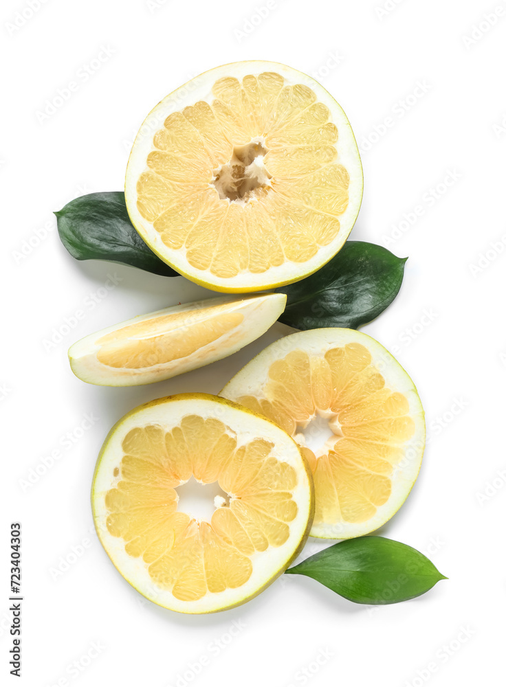 Cut fresh pomelo fruit and leaves on white background