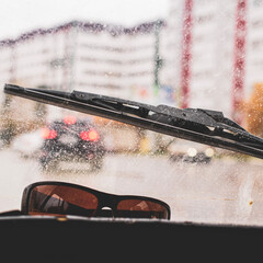 Wall Mural - Windshield wipers from inside of car, season rain. The problem of poor road visibility and traffic hazards on the road