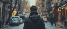 Man In Black Jacket Walking Alone On City Street From Behind In Slow Motion.
