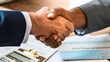 A handshake over a financial contract, symbolizing trust and collaboration in business and financial transactions
