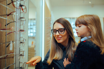 Wall Mural - Mother and Daughter Choosing Eyeglasses Frames Together in a Store. Cheerful family looking for a fitting pair of glasses for kids 
