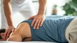 In a clinic setting, a therapist is providing a back sports massage to a male athlete patient