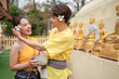 © EmmaStock - On Songkran Day, young Thai people wear Thai costumes to bathe Buddha statues and play on Songkran Day.