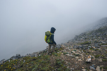 Wall Mural - Woman hiker climbing to mountain top in tibet