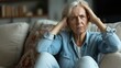 © Sasint - Rear view close up thoughtful mature woman touching forehead, suffering from headache, sitting on couch at home alone, pensive upset middle aged female lost in thoughts, thinking about problems