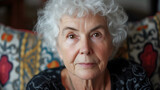 Fototapeta  - A captivating portrait of an elegant elderly woman with short, curly white hair and warm brown eyes, radiating timeless beauty and wisdom. Her serene smile reflects a life lived to the fulle