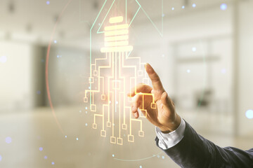 Poster - Male hand working with virtual creative light bulb with chip hologram on blurred office background, artificial Intelligence and neural networks concept. Multiexposure