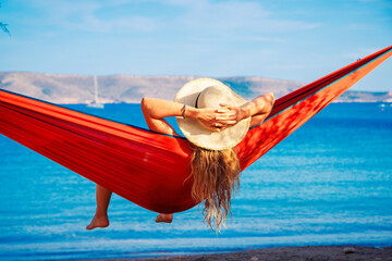 Wall Mural - summer vacation concept, woman relaxing in bikini in hammock on tropical beach