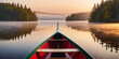 Canoe gliding through a misty lake at sunset, AI-generated.