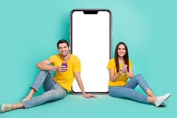 Poster - Photo of cheerful pretty married couple wear yellow t-shirts writing sms gadget empty space isolated teal color background