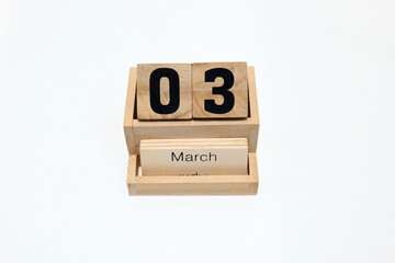 Close up of a wooden perpetual calendar showing the 3rd of March. Shot close up isolated on a white background