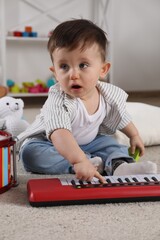 Wall Mural - Cute little boy playing toy piano at home