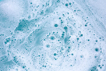 Wall Mural - Detergent foam bubble on water. Blue background, Soap sud