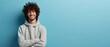 Portrait of happy man with curly hair smile toothily keeps arms down wears casual hoodie looks cheerful isolated over blue background being in good mood with copy space. Generative ai
