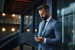 © FutureStock - Handsome business man leader using phone while standing in modern office.