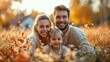 © AdriFerrer - Joyful family with a toddler sitting in a meadow during autumn.