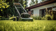 Lawn mower on green grass in summer garden. Gardening concept .