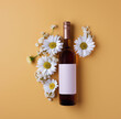 A pink wine bottle with floral accents decorated with white daisies on a warm yellow background creates a fun and eye-catching presentation.
