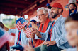 © Drazen - USA sports fans waving with flags while spectating match from stadium stands.