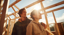 couple standing inside wooden frame construction of their future home. construction