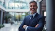 © PixelPrompt - portrait of successful senior businessman consultant looking at camera and smiling inside modern office building