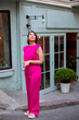© Евгений Ихонкин - Confident elegant woman in a pink suit stands and looks up. Full length portrait of a middle-aged woman