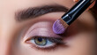 Woman applying eye shadow with makeup brush. Makeup for a young beautiful girl.  Close up