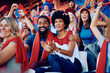 © Drazen - Happy black couple cheering while speciating sports championship at stadium.