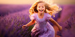 A happy girl runs and has fun in a lavender field. Happy child playing in a meadow of blooming lavender.