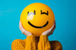 a studio portrait of a person holding a social media emoji character face over their head