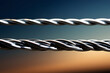 © D - Close-up of a metal cable against a blurred background of blue sky and setting sun