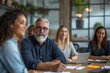 © Molang Visual - A group of people are sitting around a table having a meeting.