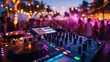 © amila - Portrait of dj mixer turntable equipment at beach party, people are dancing in background