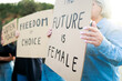 Crowd of women protest for female rights holding banners at demonstration in road city. Power, freedom, equality concept