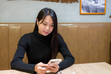 Wall Mural - Woman use of mobile phone in restaurant