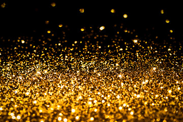 Wall Mural - Gold glitter on black background.