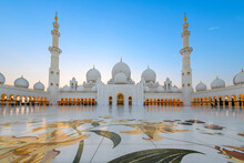 Interior Courtyard Of The Sheikh Zayed Grand Mosque, The Largest Mosque In The UAE, Illuminated At Twilight In Abu Dhabi, United Arab Emirates.