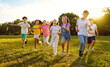 © Studio Romantic - Happy, joyful, carefree kids playing together in summer. Children enjoying free time, playing and having fun. Group of cheerful little friends running on a grassy lawn in a green sunny park