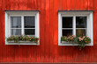 White windows with flowers on red wooden wall in Porvoo, Finland
