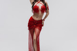 The part of body, Legs of a Female Dancer. Oriental belly dance girl in national red dress. Stunning female body. Foot movement in oriental dance. Elegant skirt beautifully spinning in the dance