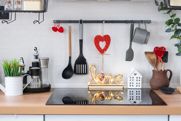 Wall Mural - The interior of the kitchen in the house is decorated with red hearts for Valentine's Day. Decor on the table, stove, utensils, festive mood in a family nest