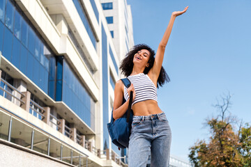 Poster - Photo of cheerful glad positive girl raise hand walk after university lectures relax rest free time spring outside