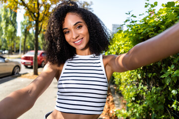 Sticker - Photo of stunning positive cute curly haired girl recording video streaming showing city sunny weather outdoors