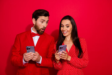 Aufkleber - Photo of two lovers girl showing smart phone screen impressed man isolated on bright red color background