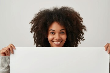 Poster - A woman holding up a white sign in front of her face. Suitable for advertising and promotional purposes