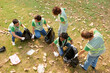 © DragonImages - Group of eco volunteers collecting garbage on college campus