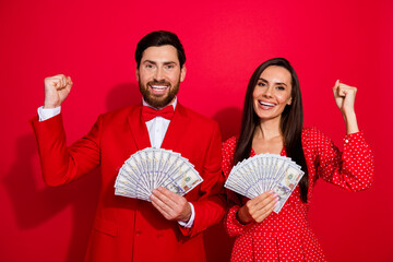 Aufkleber - Photo of two positive delighted people hold dollar bills banknotes raise fists success isolated on red color background
